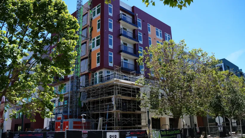 Modern dark purple and orange apartment building in Santa Cruz, California on sunny day.