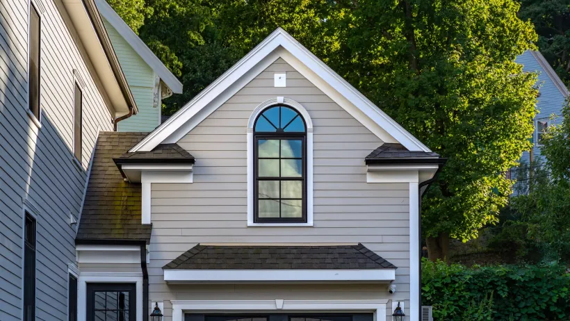 Close-up on gabled roof with window over garage.