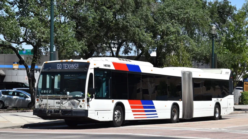 White articulated transit bus with blue and red stripes in Houston, Texas.