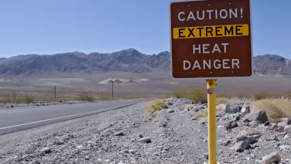 "Caution! Extreme heat danger" sign in Death Valley National Park with desert mountains in background
