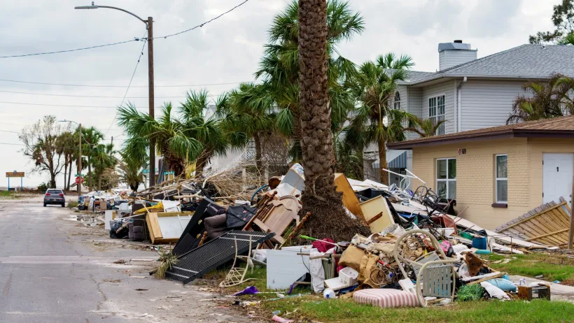 Houses with debris from hurricane piled on front lawns in Florida.