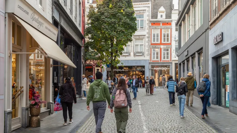 People walking on cobblestone street between old buildingsin Maastricht, Netherlands.