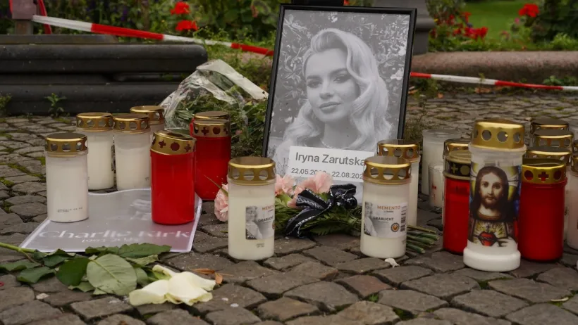 Memorial for Iryna Zarutska in Berlin, Germany with black and white portrait surrounded by candles.