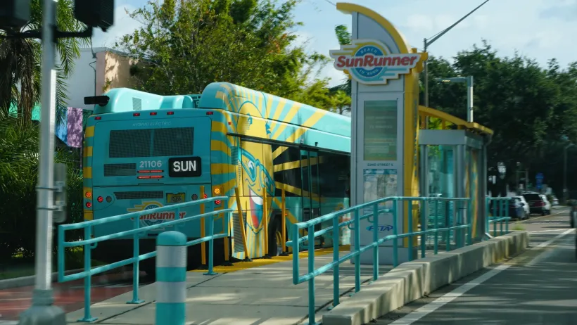 Green Sunrunner bus at elevated mid-street bus stop with dedicated bus lane in St. Petersburg, Florida.