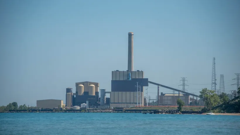 The J.H. Campbell Generating Plant, a concrete building in front of a large body of water.