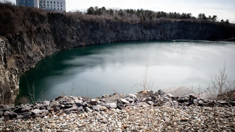 A quarry in Maine, filled with water and surrounded by stones.