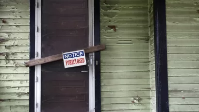 Vacant home with foreclosure sign.