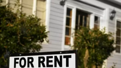 For rent sign with blurry house in background