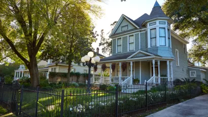 Light blue two-story Victorian home with corner turret in The Heights, Houston, Texas