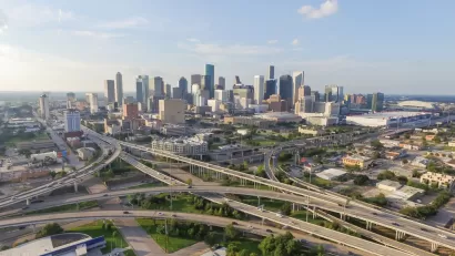 Aerial view of Houston freeway interchanges with downtown skyline in background