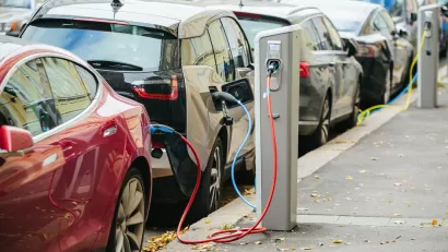 Electric cars parked curbside and charging on a city street