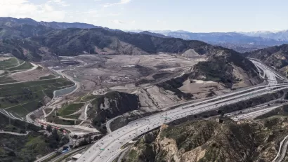 Aerial view of I-5 freeway and large landfill in hilly part of Los Angeles County