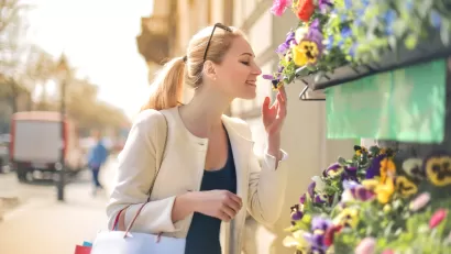 Woman smelling flowers at a street stand
