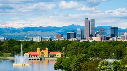 Denver, Colorado skyline with park and lake in foreground and mountains in background