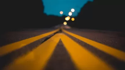 Blurred view from ground level of yellow center lines on asphalt street