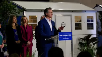 California Governor Gavin Newsom announcing funding for tiny home shelter project in front of quick-build tiny home shelter unit.