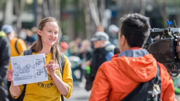 Current Seattle mayor-elect Katie Wilson holding up a sign during a transit protest.