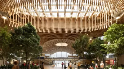 Indoor view of PDX's new massive airport terminal with a wooden beamed roof and skylight.