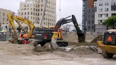 Yellow electric excavator digging at construction site in Los Angeles, California.