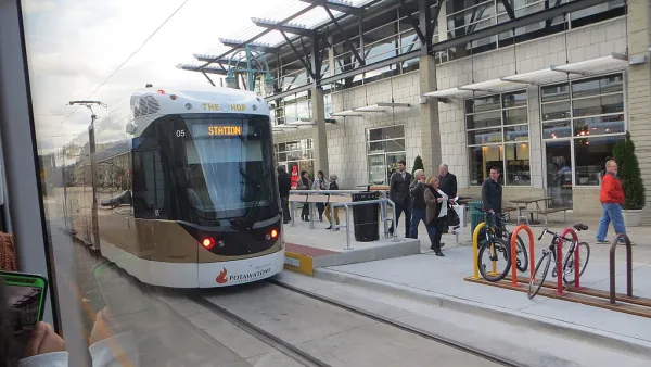 A white streetcar pulls into a station