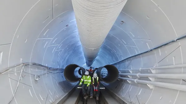 Two workers inside white Boring Company tunnel in Hawthorne, California.