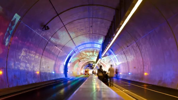 Tunnel for pedestrians, bikes, and buses in Lyon, France lit up with purple lights.