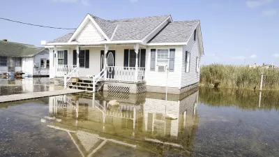White house surrounded by several inches of tidal floodwaters.