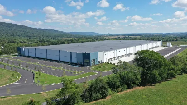 A large warehouse from the outside with parking lot exterior