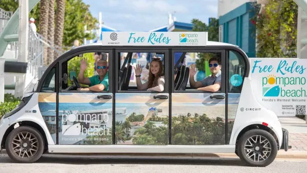 Small white microtransit shuttle with wrap depicting beach town in Pompano Beach, Florida with happy people waving from inside.