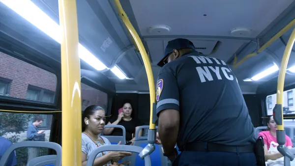 An officer scans a bus rider's pass 