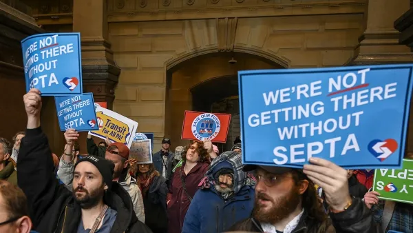 People holding up signs at a protest to save SEPTA funding.
