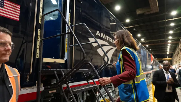 New York Governor Kathy Hochul climbing onto Amtrak train.