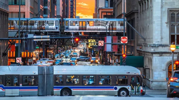 White CTA bus and elevated train against sunset sky in downtown Chicago, Illinois.
