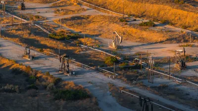 Aerial view of oil field in California with pumpjacks at sunset.