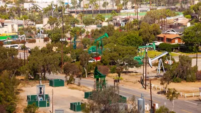 View of green oil wells in a residential neighborhood in California.