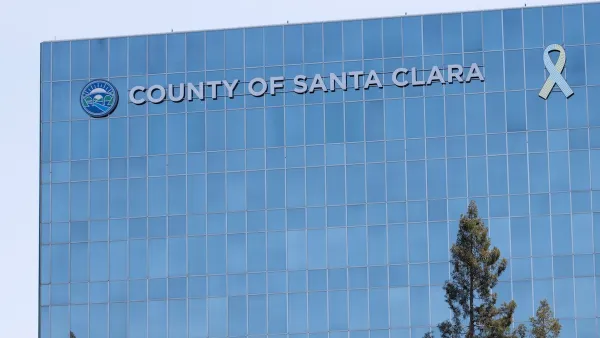 Flat modern glass office tower with "County of Santa Clara" sign.