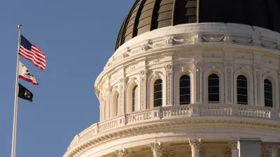 Close-up of Californis state capitol dome with U.S., California, and POW/MIA flags on flagpole.