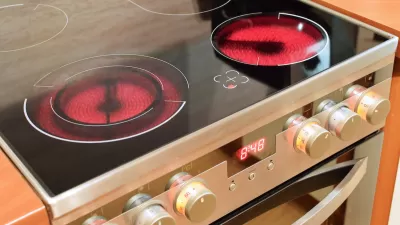 Close-up of electric stove range with front burners red-hot.