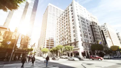 Intersection in downtown Los Angeles with pedestrians crossing, vintage building across street, and modern glass office tower in background.