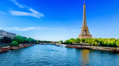 View from middle of River Seine in Paris with Eiffel Tower on right side.
