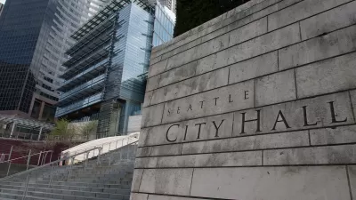 Close-up of carved Seattle City Hall title on front of concrete buildin next to staircase.