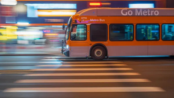 Orange Los Angeles Metro bus passing on blurred street at night.