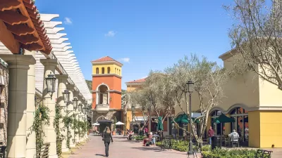 Suburban outdoor mall in muted colors with decorative tower.