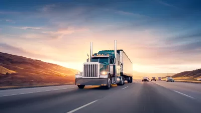 Semi truck driving down freeway with twilight sky in background.