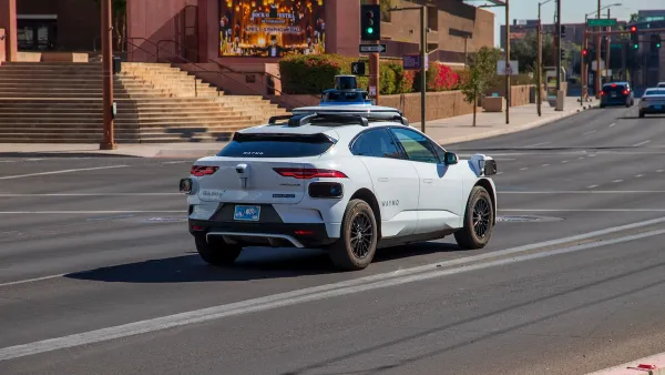 White Waymo self-driving vehicle in front of Phoenix Convention Center.