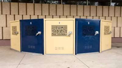 Blue and beige secure bike lockers in underground passageway etched with bicycle logo