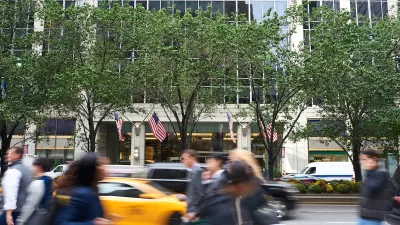 Blurred pedestrians walkingon NYC sidewalk with blurred yellow cab in background.