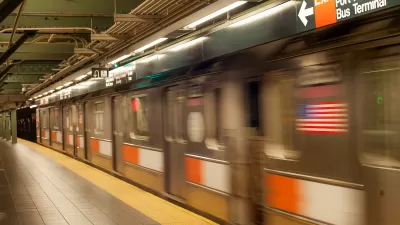 Blurred NYC subway train passing by empty platform with yellow strip.