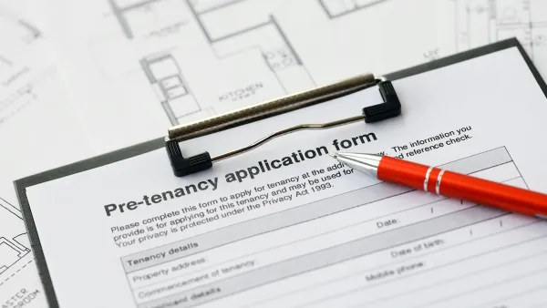 Close-up on clipboard with pre-tenancy application and red pen.