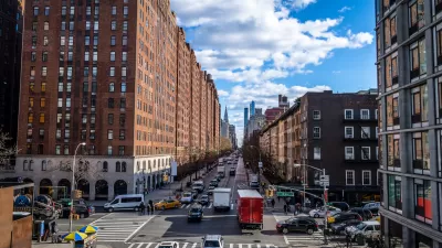 New York City street with some traffic with red brick buildings on either side